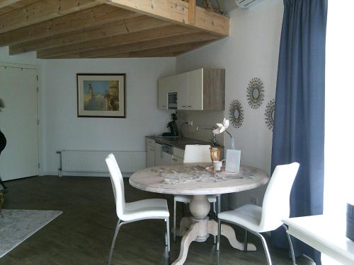 ein Esszimmer mit einem Tisch und weißen Stühlen in der Unterkunft BedStay41 in Oudewater