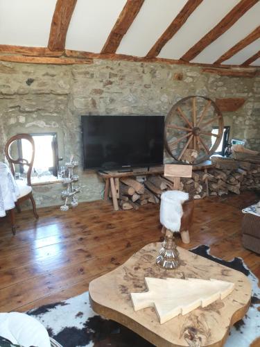 a living room with a tv and a wooden floor at La Petite Chapelle in Font-Romeu