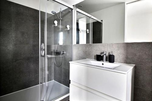 een badkamer met een witte wastafel en een douche bij Rent a Flat - Bruxelles in Brussel