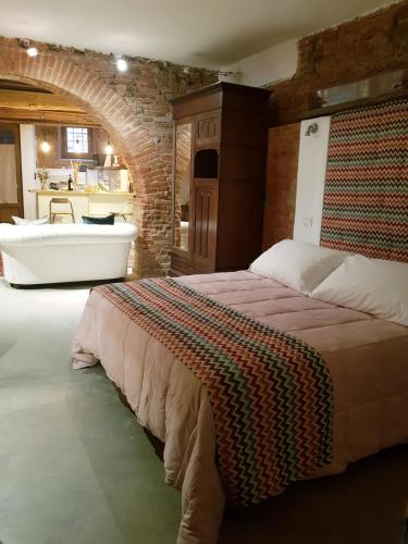 a bedroom with a large bed and a bath tub at L' Atelier Tuscany in Peccioli