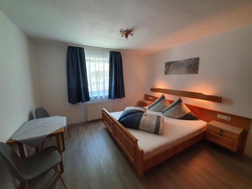 1 dormitorio con cama, mesa y escritorio en Haus Bergheimat, en Sankt Leonhard im Pitztal