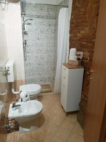 e bagno con servizi igienici, doccia e lavandino. di L' Atelier Tuscany a Peccioli