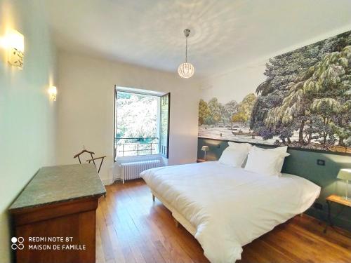 a bedroom with a large bed and a painting on the wall at VILLA SERANDITE maison de famille in Annecy