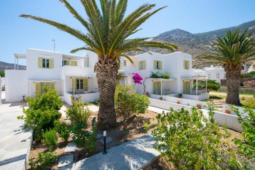 een uitzicht op een villa met palmbomen bij Morpheas Pension Rooms & Apartments in Kamarai