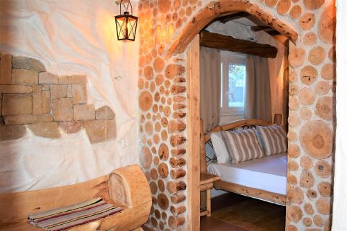 a bedroom with a bed in a stone wall at The Flintstones House in Limenaria