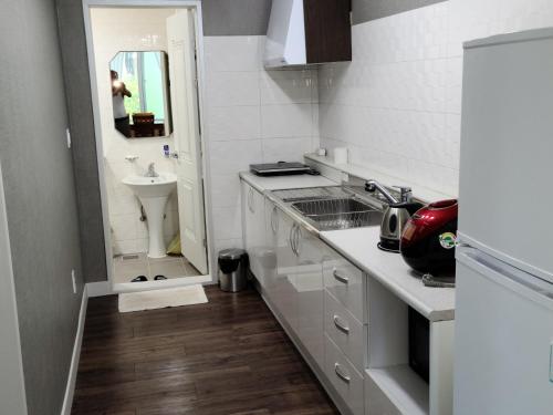 a white kitchen with a sink and a toilet at Santafe in Namhae