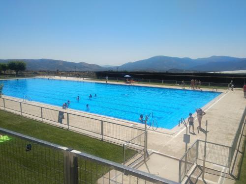 een groot blauw zwembad met mensen erin bij Los pisitos de El Barraco 1 in El Barraco