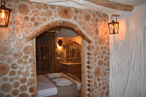 una camera con due letti e un muro di pietra di The Flintstones House a Limenaria