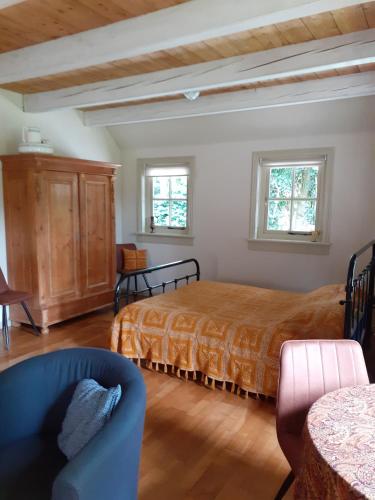 a bedroom with a bed and a blue chair at B&B Oudeschans in Oudeschans