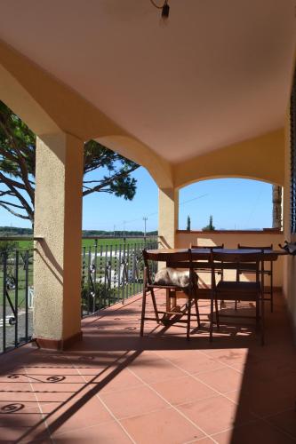 patio con mesa y sillas en el balcón en Agriturismo Beveraggio Appartamenti en Marina di Grosseto