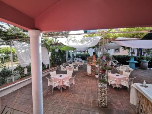 un patio al aire libre con mesas, sillas y sombrillas blancas en El Tio Mateo, en Marbella