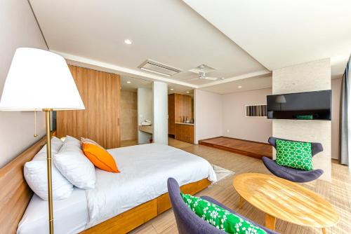 a bedroom with a bed and a table and chairs at Jeju Bom stay & Art Gallery in Seogwipo