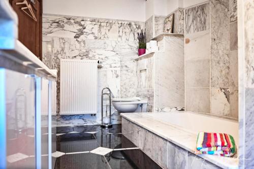 a bathroom with a tub and a toilet at Landhaus Lontzen in Lontzen
