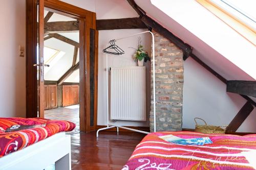 um quarto no sótão com uma escada e um aquecedor em Landhaus Lontzen em Lontzen