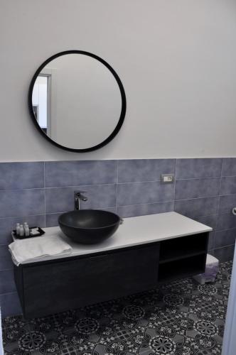 a bathroom with a black sink and a mirror at Calise Guest house in Procida