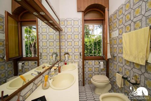 un bagno con due lavandini e un WC di Villa Lydia a Padenghe sul Garda