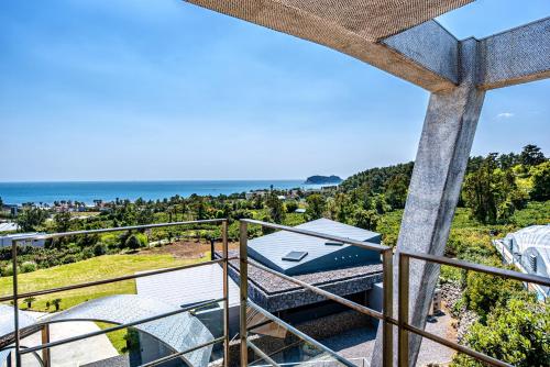 an ocean view from the balcony of a house at Jeju Bom stay & Art Gallery in Seogwipo