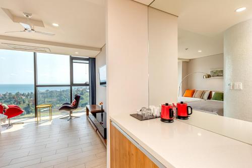 a kitchen and living room with a view of a bedroom at Jeju Bom stay & Art Gallery in Seogwipo