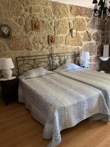 a bedroom with a bed and a stone wall at Quinta Formosa in Vale Formoso