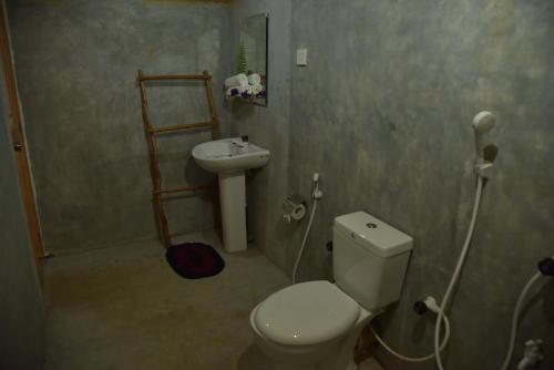 a bathroom with a toilet and a sink at Rainforest Nature House in Deniyaya