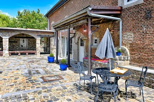 a patio with a table and chairs and an umbrella at Landhaus Lontzen in Lontzen