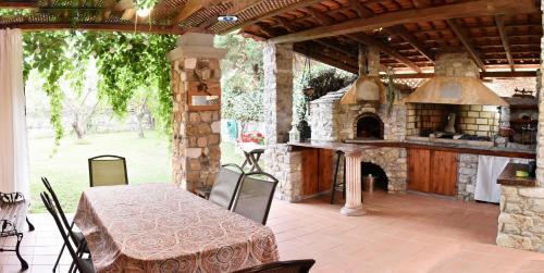 una cocina al aire libre con mesa y horno de piedra. en Makis & Dimitra House, en Palaión Tsiflíkion