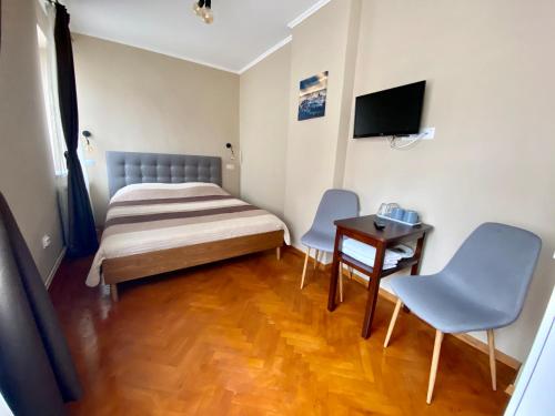 sypialnia z łóżkiem, stołem i krzesłami w obiekcie Johann Gott Suite w Braszowie