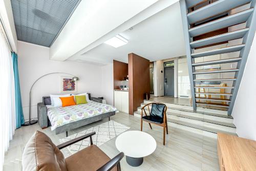 a bedroom with a bed and a staircase at Jeju Bom stay & Art Gallery in Seogwipo