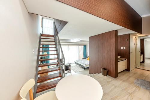 a room with a spiral staircase leading to a bedroom at Jeju Bom stay & Art Gallery in Seogwipo