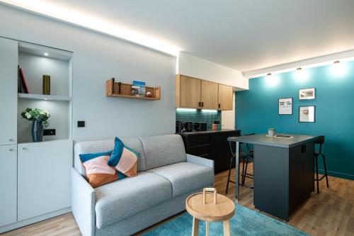 uma sala de estar com um sofá e uma mesa em NEW - Superbe 1 Bdr Appt - Design 60'S - Paris 15e em Paris
