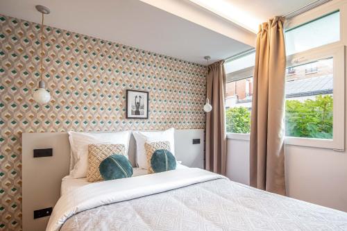 une chambre avec un grand lit et une fenêtre dans l'établissement NEW - Superbe 1 Bdr Appt - Design 60'S - Paris 15e, à Paris