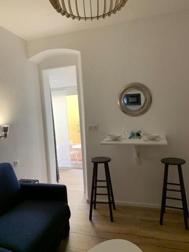 - un salon avec un canapé et deux tabourets de bar dans l'établissement Studio terrasse rue piétonne Ajaccio, à Ajaccio