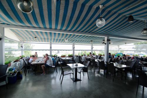 un ristorante con soffitto blu con persone sedute ai tavoli di Hotel Belona a Eforie Nord