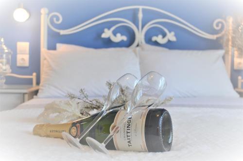 a bed with a bottle of wine and two spoons at Hotel Kastro in Skiathos Town