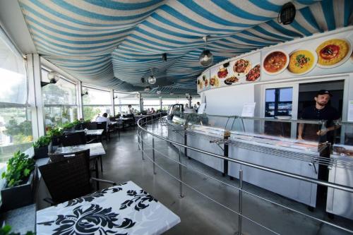 un ristorante con un soffitto a strisce blu e bianche di Hotel Belona a Eforie Nord