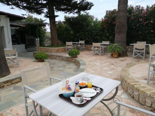 a white table with food and drinks on a patio at 7 Islands in Spetses