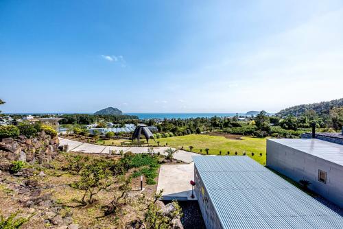 an aerial view of a building with the ocean in the background at Jeju Bom stay & Art Gallery in Seogwipo