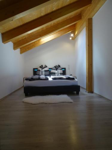 因澤爾的住宿－Ferienwohnung Anastasia，一间带一张床的卧室,位于带木制天花板的房间内