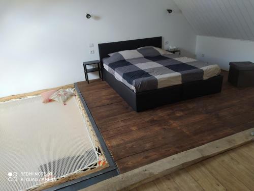 a bedroom with a bed and a wooden floor at Gîte L'atelier in Civray-de-Touraine