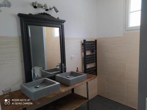łazienka z 2 umywalkami i dużym lustrem w obiekcie Gîte L'atelier w mieście Civray-de-Touraine