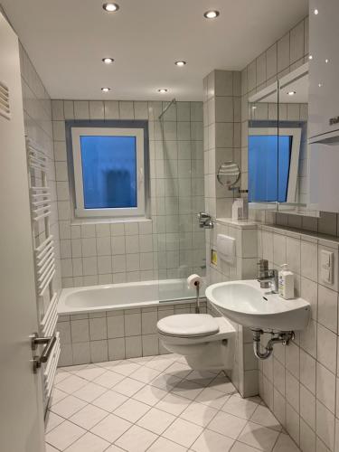 a bathroom with a toilet and a sink and a tub at Apartment im Zentrum in Kassel