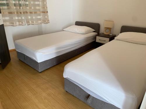 two twin beds in a room with at Apartment old town in Primošten