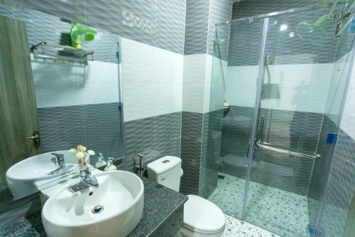 ein Bad mit einem Waschbecken, einer Dusche und einem WC in der Unterkunft Khách sạn Minh Anh in Tuy Hoa