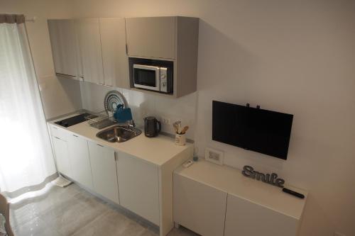 a small kitchen with a sink and a microwave at Vila Snježana Tučepi in Tučepi