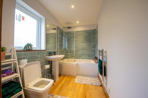 a bathroom with a toilet and a tub and a sink at The GREENHOUSE in Aberfeldy
