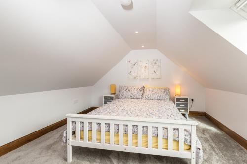 a bedroom with a white bed in a attic at The GREENHOUSE in Aberfeldy