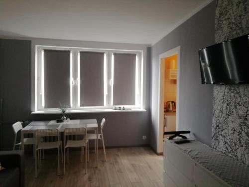 a dining room with a table and chairs and a window at Apartament Biała Mewa in Władysławowo