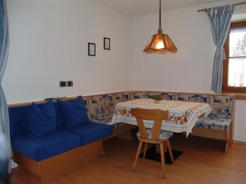 a living room with a blue couch and a table at Appartement Gandler in Valdaora