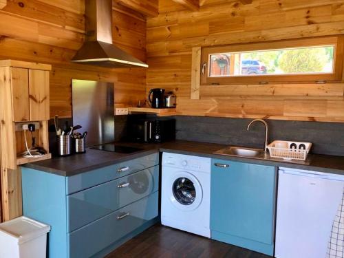 - une cuisine avec lave-linge et sèche-linge dans une cabine dans l'établissement Studio-Mazot de charme 26 m2 Parc Chartreuse, à Vimines