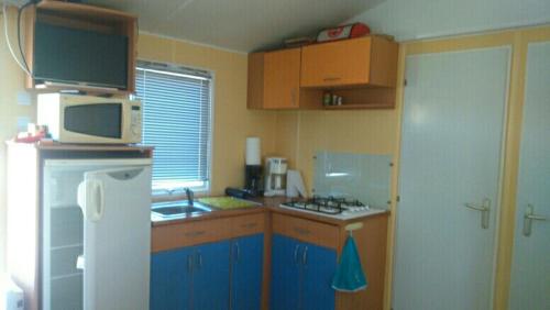 a kitchen with blue cabinets and a white refrigerator at ETANG PRE DE LA FONT in Cercles